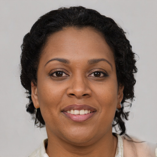 Joyful black adult female with short  brown hair and brown eyes