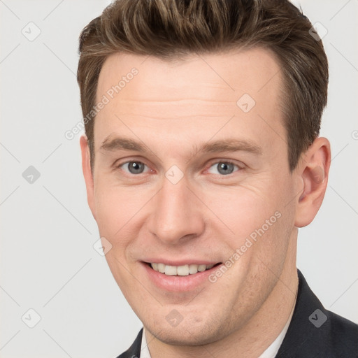 Joyful white young-adult male with short  brown hair and grey eyes