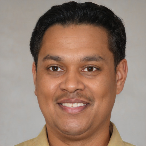 Joyful latino adult male with short  black hair and brown eyes