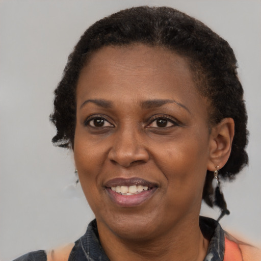 Joyful black adult female with short  black hair and brown eyes