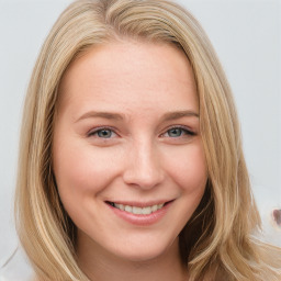 Joyful white young-adult female with long  brown hair and blue eyes