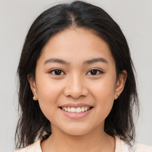 Joyful latino young-adult female with medium  brown hair and brown eyes