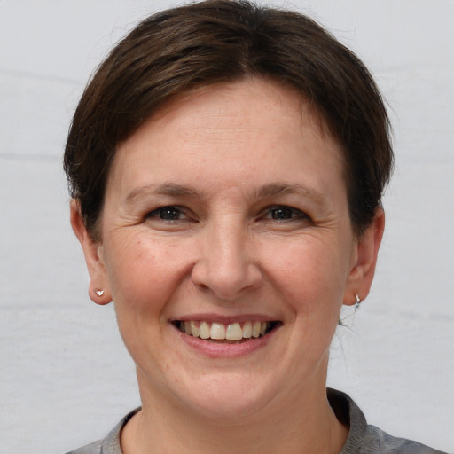 Joyful white adult female with short  brown hair and grey eyes