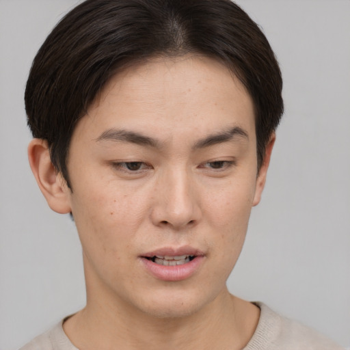 Joyful asian young-adult male with short  brown hair and brown eyes