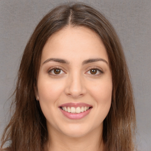 Joyful white young-adult female with long  brown hair and brown eyes