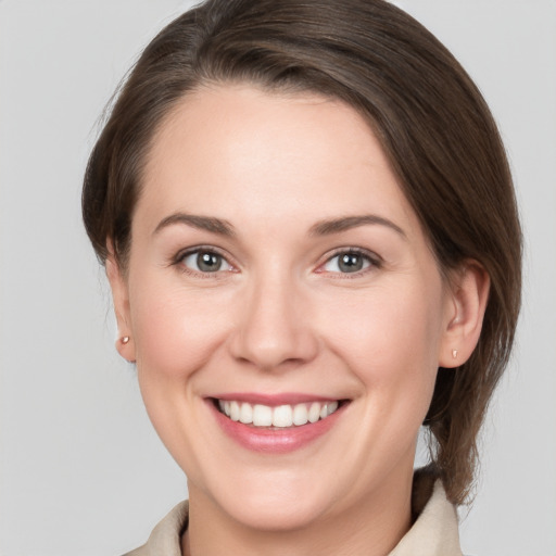 Joyful white young-adult female with medium  brown hair and grey eyes