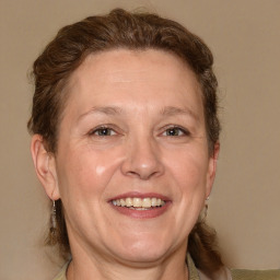 Joyful white adult female with medium  brown hair and blue eyes