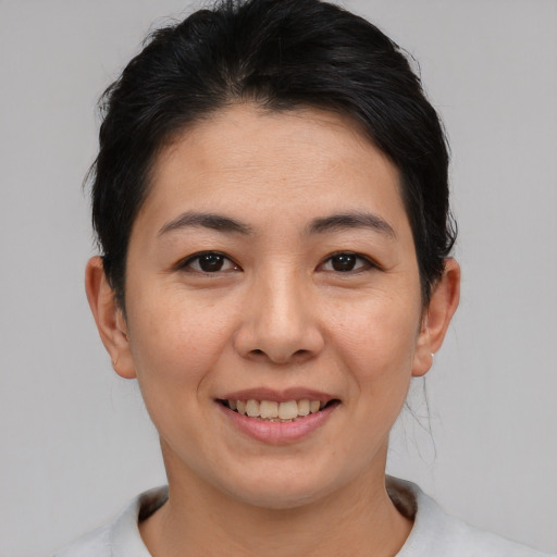 Joyful asian young-adult female with short  black hair and brown eyes