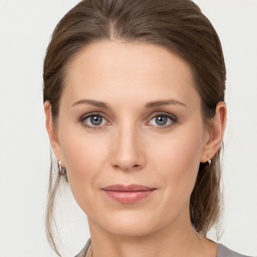 Joyful white young-adult female with medium  brown hair and grey eyes