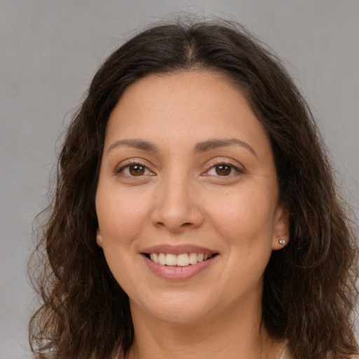 Joyful white adult female with long  brown hair and brown eyes