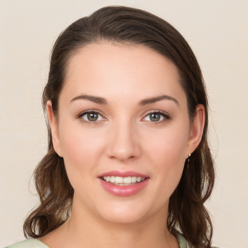 Joyful white young-adult female with medium  brown hair and grey eyes