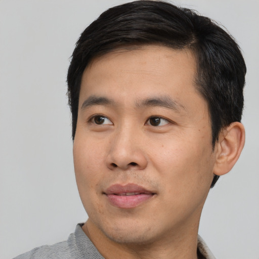Joyful asian young-adult male with short  black hair and brown eyes