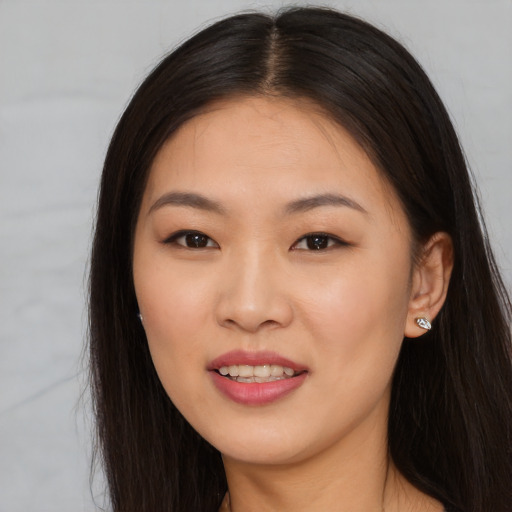 Joyful asian young-adult female with long  brown hair and brown eyes