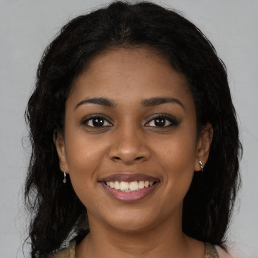 Joyful black young-adult female with long  black hair and brown eyes