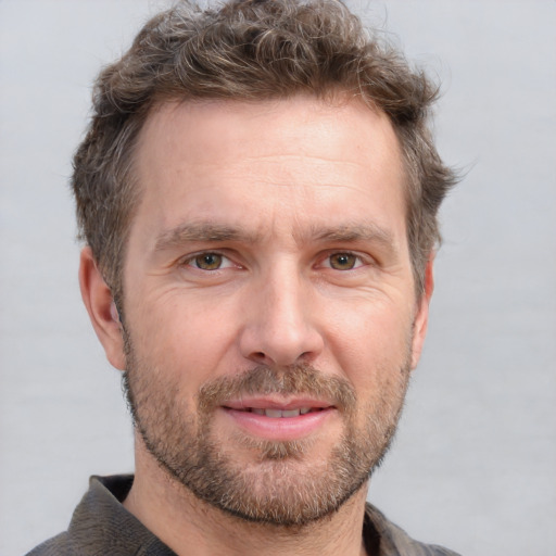 Joyful white adult male with short  brown hair and grey eyes