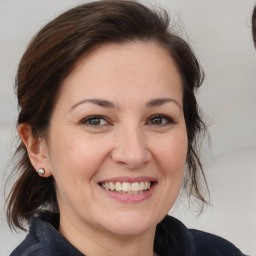 Joyful white adult female with medium  brown hair and brown eyes