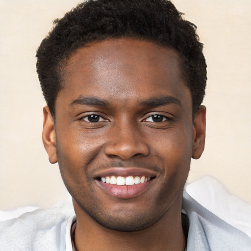 Joyful black young-adult male with short  brown hair and brown eyes