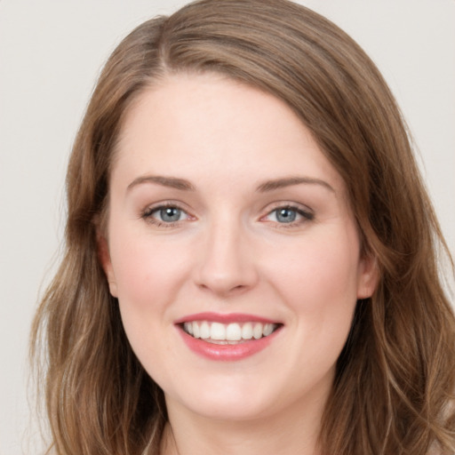 Joyful white young-adult female with long  brown hair and grey eyes