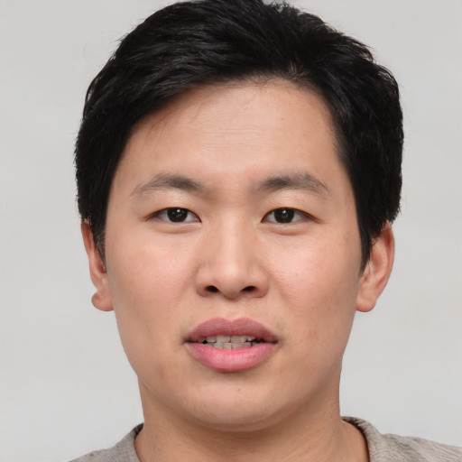 Joyful asian young-adult male with short  black hair and brown eyes