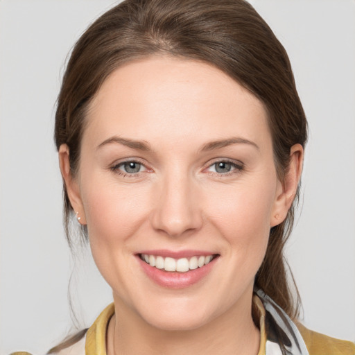 Joyful white young-adult female with medium  brown hair and grey eyes