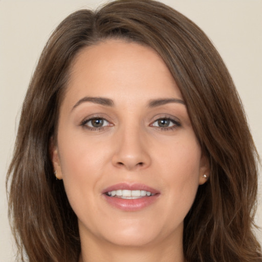 Joyful white adult female with long  brown hair and brown eyes