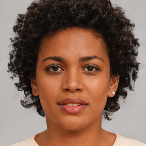 Joyful black young-adult female with medium  brown hair and brown eyes