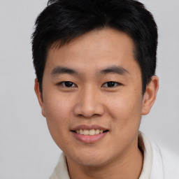 Joyful asian young-adult male with short  brown hair and brown eyes