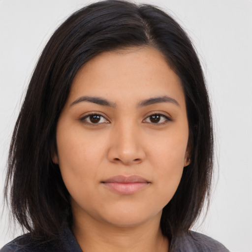 Joyful latino young-adult female with long  brown hair and brown eyes