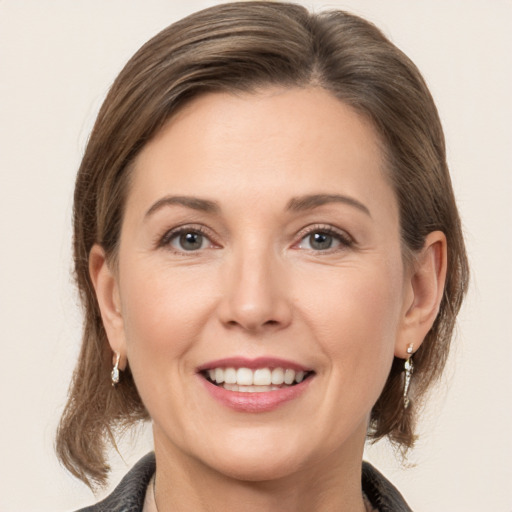 Joyful white young-adult female with medium  brown hair and grey eyes