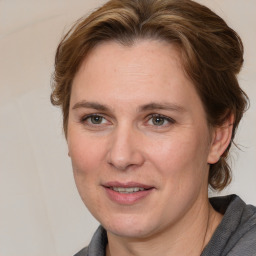 Joyful white adult female with medium  brown hair and blue eyes