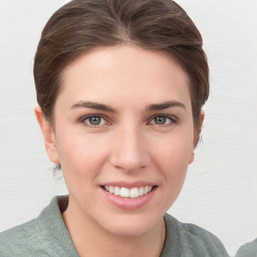 Joyful white young-adult female with short  brown hair and grey eyes