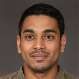 Joyful latino young-adult male with short  black hair and brown eyes