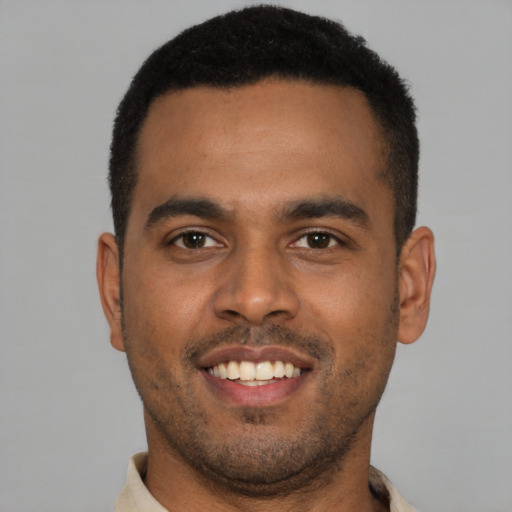 Joyful black young-adult male with short  brown hair and brown eyes