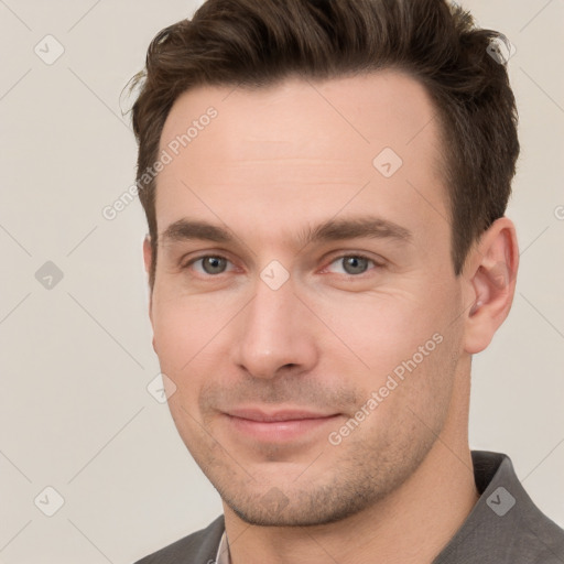 Joyful white young-adult male with short  brown hair and grey eyes