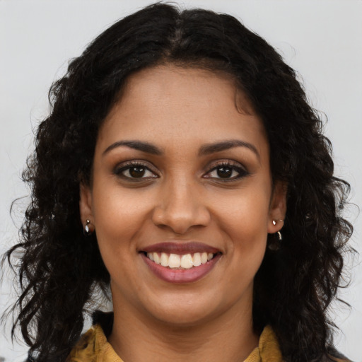 Joyful black young-adult female with long  brown hair and brown eyes