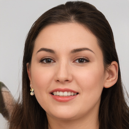 Joyful white young-adult female with long  brown hair and brown eyes