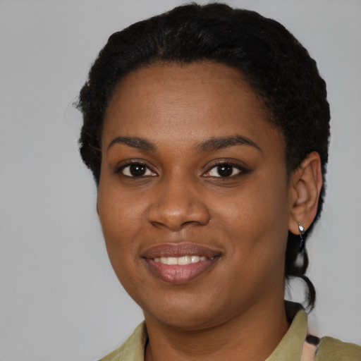 Joyful black young-adult female with short  black hair and brown eyes