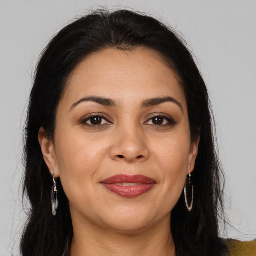 Joyful latino adult female with long  brown hair and brown eyes