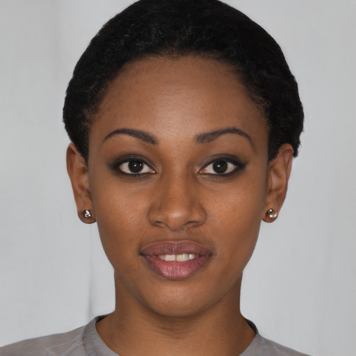 Joyful black young-adult female with short  black hair and brown eyes