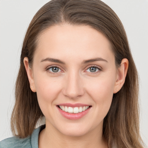 Joyful white young-adult female with long  brown hair and grey eyes