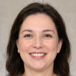 Joyful white adult female with medium  brown hair and brown eyes