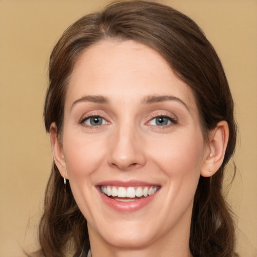 Joyful white young-adult female with long  brown hair and green eyes