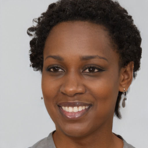 Joyful black young-adult female with short  brown hair and brown eyes