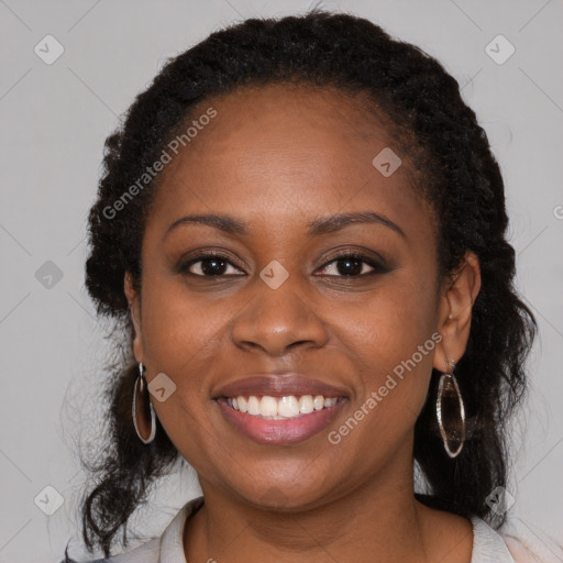 Joyful black young-adult female with long  brown hair and brown eyes