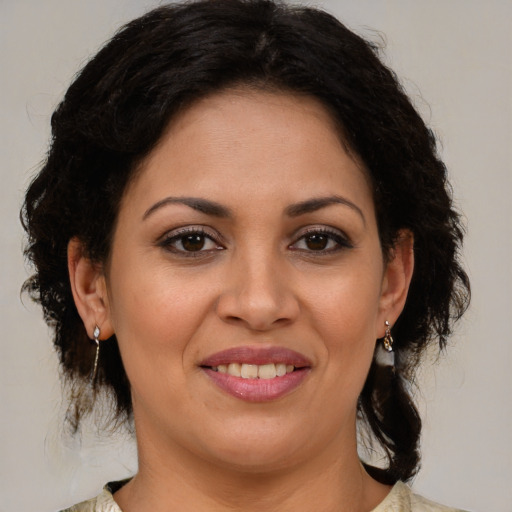 Joyful latino adult female with medium  brown hair and brown eyes