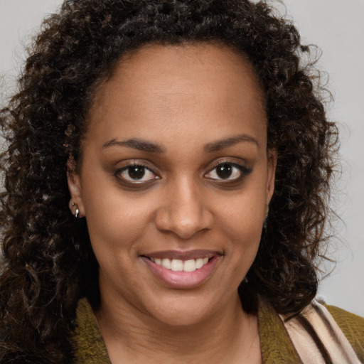 Joyful black young-adult female with medium  brown hair and brown eyes