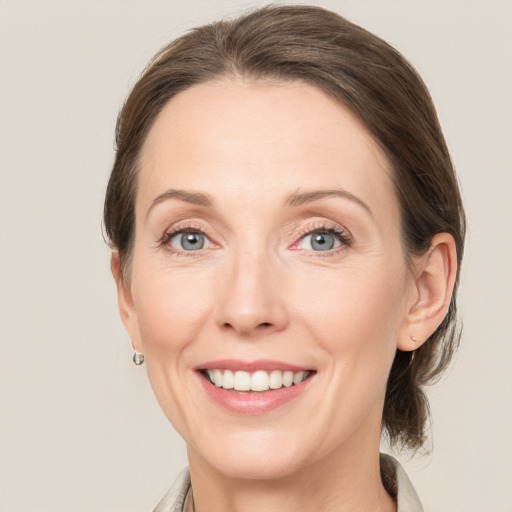 Joyful white adult female with medium  brown hair and grey eyes