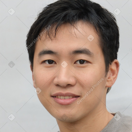 Joyful asian young-adult male with short  black hair and brown eyes