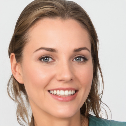 Joyful white young-adult female with medium  brown hair and blue eyes