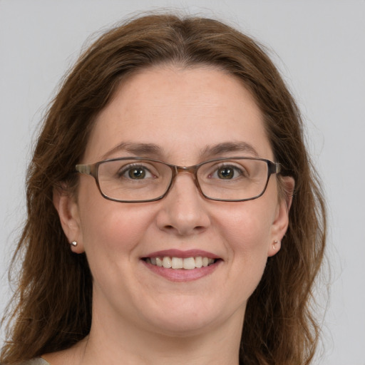 Joyful white adult female with long  brown hair and green eyes